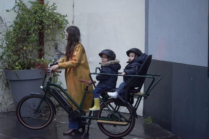 Une femme et ses enfants sur un vélo électrique cargo